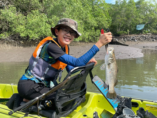 Boy catches good sized barramundi on Purehybridz Kayak Fishing Mangrove Tour in Pulau Ubin