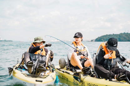 Kayak fishing guide Dom helps guest land a mangrove jack on Purehybridz Kayak Fishing Tour in Pulau Ubin