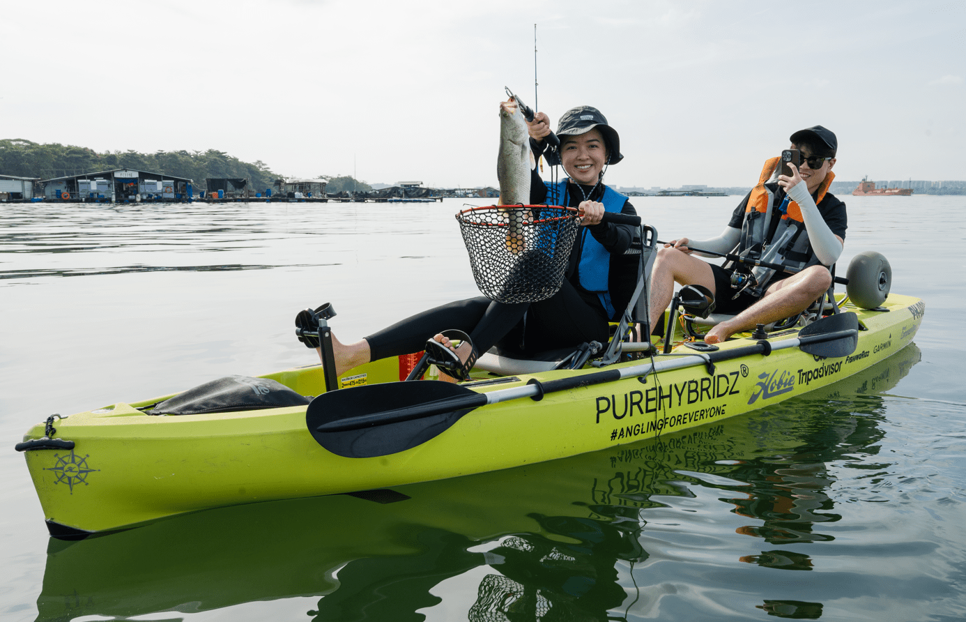 Couple catches a barramundi on Purehybridz Kayak Fishing Tour in Pulau Ubin 