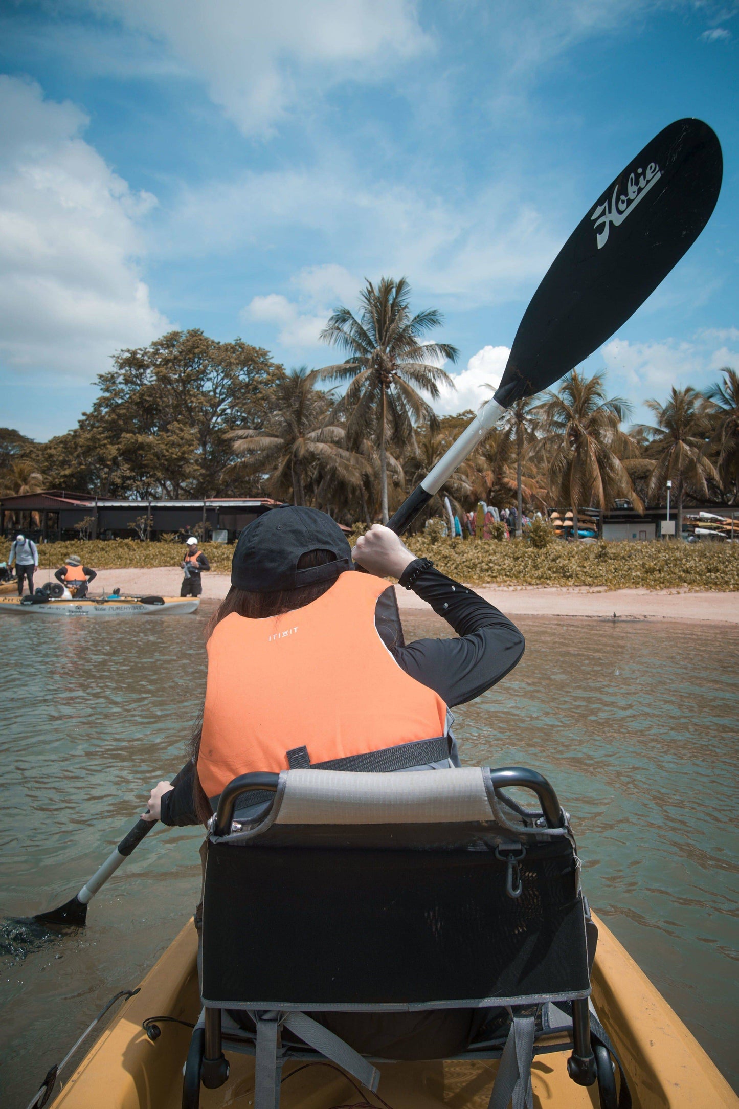 Lady angler trying out the Hobie hand paddle while fishing on Purehybridz Kayak Fishing Tours in Pasir Ris